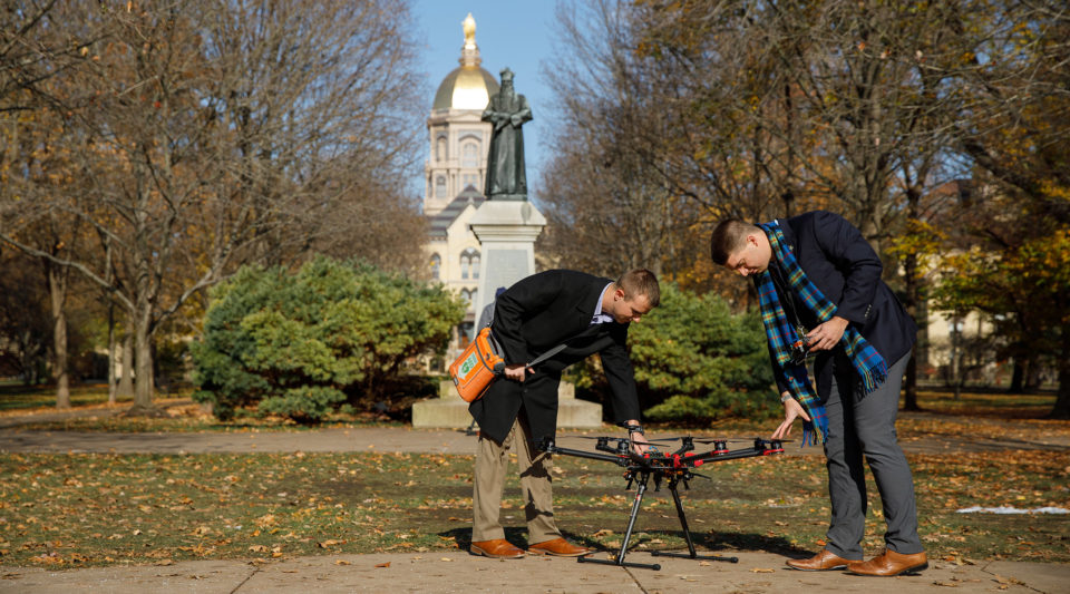 DeLive Student Co-founders Zachary Kousens ’20 and Nathaniel Hanson ’20 with a drone and aev with the Golden Dome in background